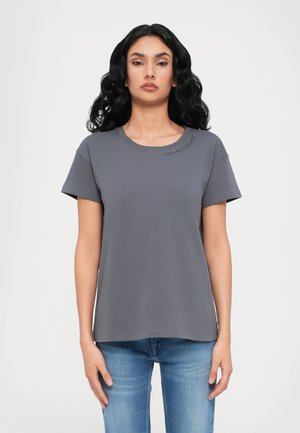 Grijze t-shirt met korte mouwen en een ronde hals, met subtiele tekstdetails op de schouder. Gemaakt van zachte stof met een ontspannen pasvorm.
