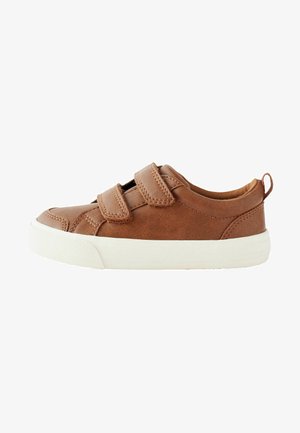 Sneaker en cuir marron avec deux bandes Velcro, semelle en caoutchouc blanche et détail de couture subtil. Bout arrondi et design bas.