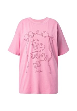 Roze katoenen T-shirt met korte mouwen, voorzien van een doorlopende lijnontwerp dat "Wees bewust" spelt, samen met lintmotieven.