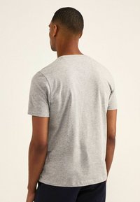 Grijze t-shirt met korte mouwen, gemaakt van zacht katoen, met een ronde halslijn en een ontspannen pasvorm. Eenvoudig ontwerp zonder zichtbare patronen of accenten.