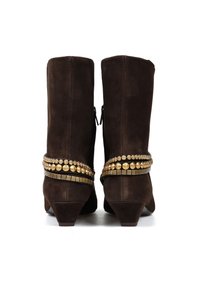 Brązowe zamszowe botki za kostkę z niskim obcasem, z ozdobnymi metalowymi detalami wokół kostki oraz zamkiem błyskawicznym jako zapięciem.