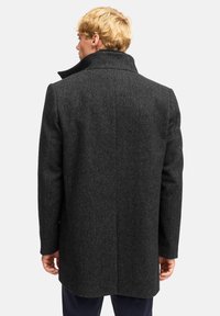 Dunkelgrauer Wollmantel mit strukturierter Oberfläche, verfügt über einen breiten Kragen und eine gerade Schnittführung. Die Rückansicht zeigt taillierte Nähte und keine Verzierungen.