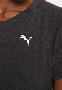 Svart t-shirt med kort ärm i ett mjukt, lätt tyg. Har en vit Puma-logotyp på framsidan. Detaljer inkluderar platta sömmar.