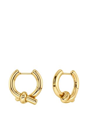 Een paar gepolijste gouden creolen met een klein knoopdetail bij de sluiting, getoond op een witte achtergrond.