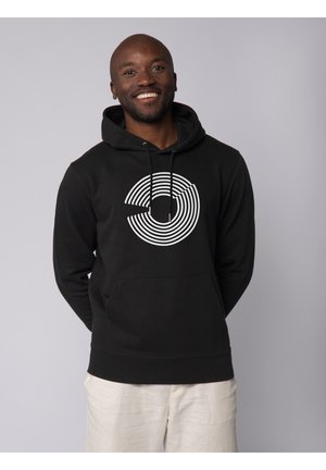 Hoodie noir avec un design à rayures circulaires blanches sur le devant. Dispose d'une poche avant et d'une capuche avec cordon de serrage, fabriqué à partir d'un tissu doux.