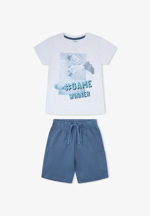 Camisa blanca de manga corta con un jugador de fútbol y texto "#GAME WINNER", combinada con pantalones cortos azules de cintura elástica con cordón y bolsillo.