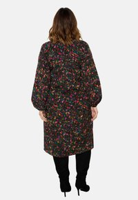 Květinové šaty s dlouhými puff rukávy, černý základ, barevné květiny. Mají volný střih a délku po kolena.