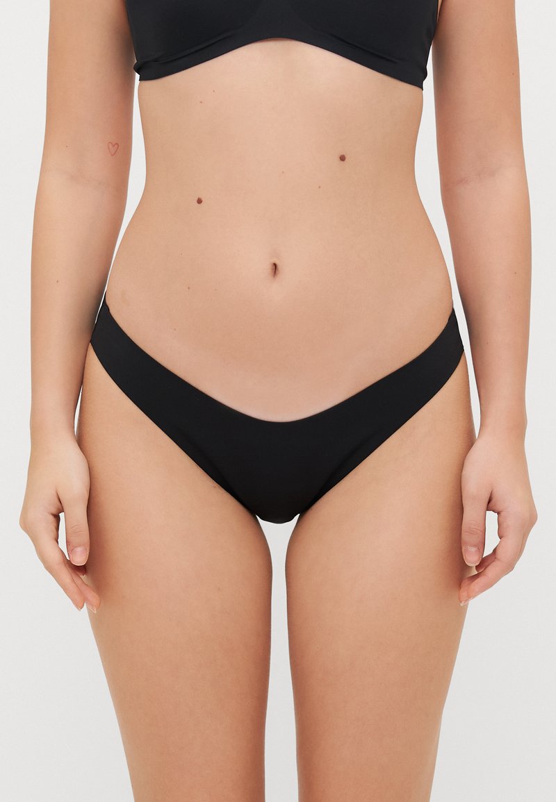Črne bikini hlačke z nizkim pasom, gladko teksturo in minimalno pokritostjo. Imajo širok pas in brezšivno obdelavo.