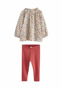 Bloemenprint lange mouwen top met geplooide halslijn, met kleurrijke prints op een witte achtergrond; gecombineerd met effen roestkleurige geribde leggings.