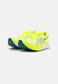 Limetkově zelené běžecké boty s mřížkovaným svrškem, modrými akcenty a zakřivenou podrážkou. Obsahují tkaničky a texturovaný vzor běhounu pro lepší přilnavost.