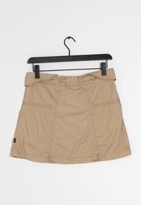 Jupe kaki en tissu texturé, dotée d'une large ceinture, de passants pour ceinture et de coutures verticales, suspendue sur un cintre noir.