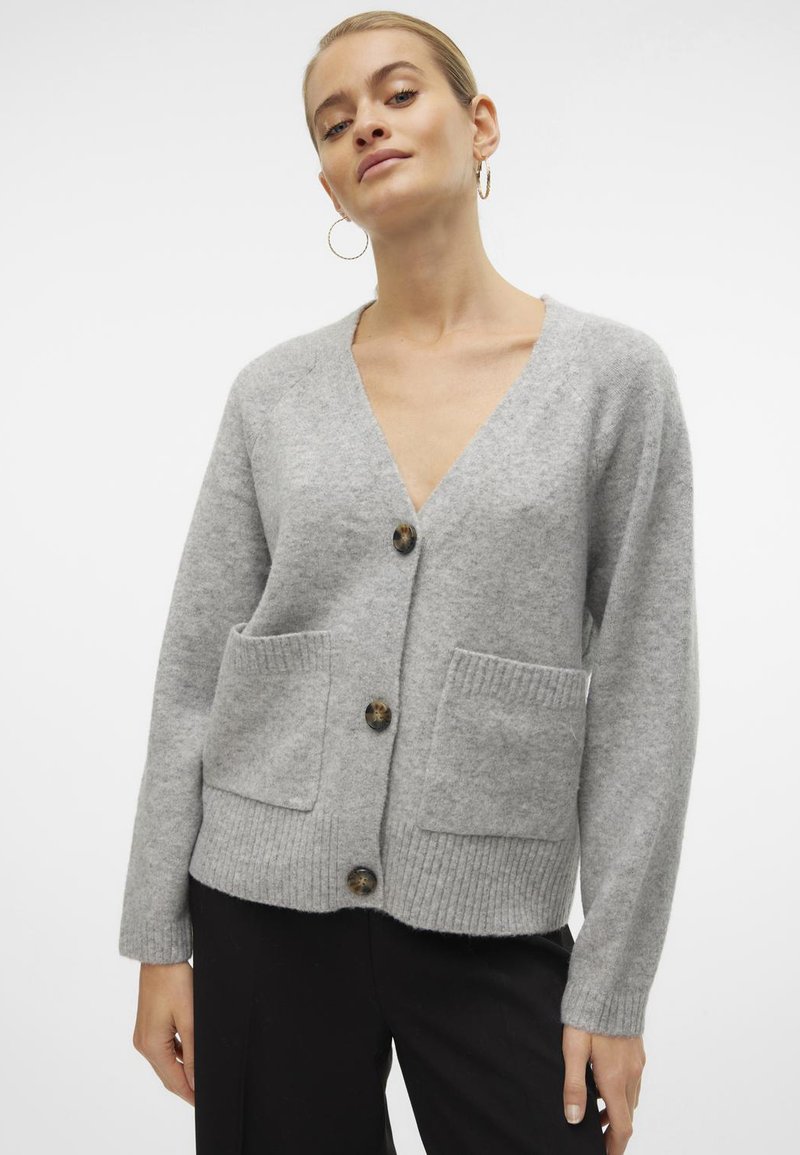 Cardigan en laine gris avec un col en V, comportant deux poches avant, des poignets côtelés et quatre boutons décoratifs au centre.