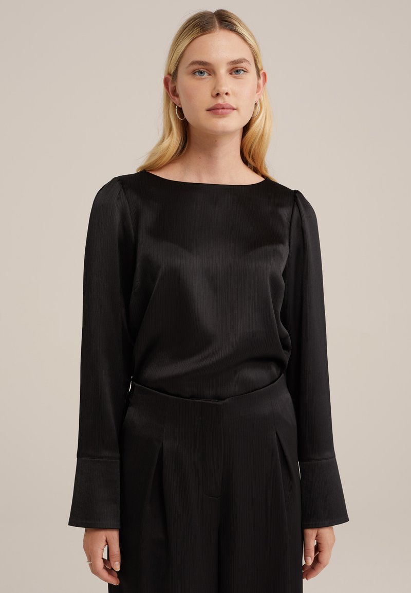 Blusa nera in satin con scollo a barca, maniche lunghe e spalle leggermente a sbuffo, caratterizzata da una texture liscia e morbida e un'elegante caduta.