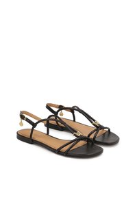Sandali neri in pelle con sottili cinturini, suole piatte e un charm dorato decorativo sulla cinghia della caviglia. Design con punta aperta dallo stile minimalista.