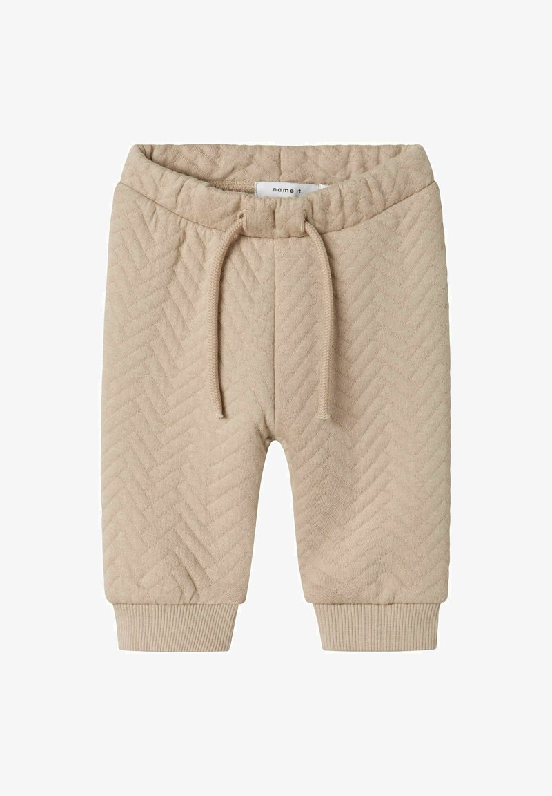 Pantalones cortos de punto beige con un patrón de espiga, cinturilla elástica con cordón de ajuste y puños acanalados en el dobladillo. Textura suave.