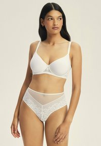 Biały zestaw koronkowej bielizny obejmuje usztywniany stanik z regulowanymi ramiączkami oraz wysokie majtki z kwiatowymi koronkowymi detalami i siateczkowymi wstawkami.
