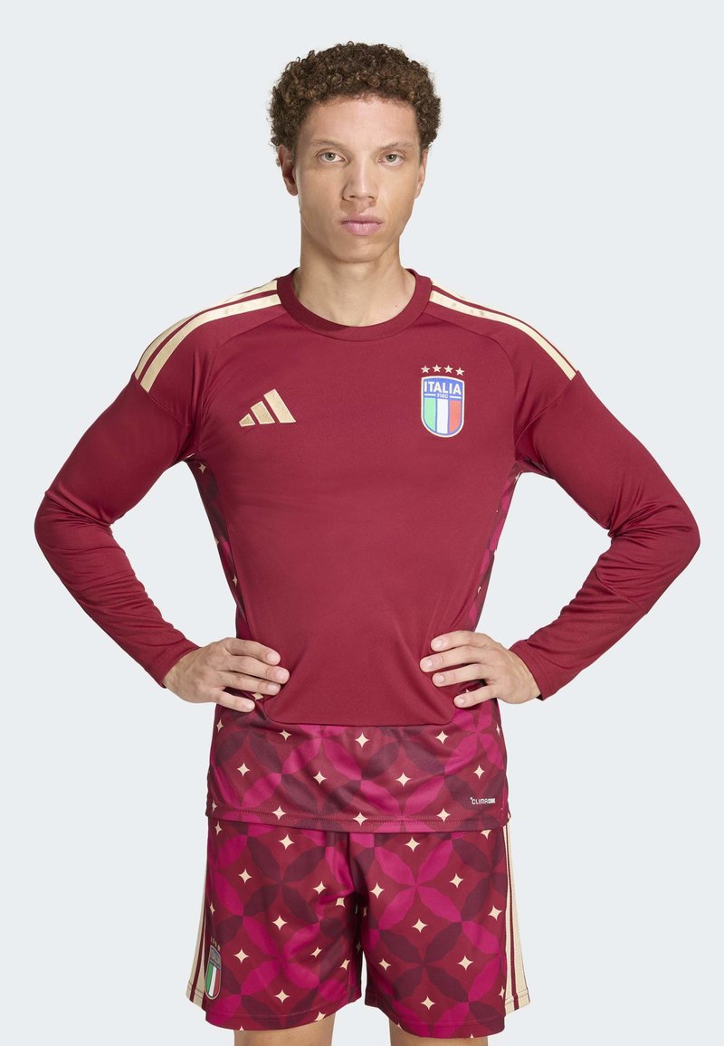 Bordo dugih rukava nogometna majica s zlatnim detaljima i emblemom Italije; kratke hlače s matching izgledom imaju teksturirani uzorak u nijansama crvene i ružičaste.