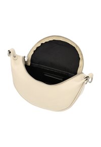 Creme læder crossbody taske med lynlås, der har et sort stofinteriør og buet design. Indeholder en sølvfarvet hardware detajle.