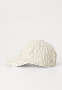 Beige színű baseball sapka, világosabb árnyalatú, egymásra rétegzett szövegmintákkal. Ívelt karimája és puha szövettextúrája van. Díszített varrásokkal rendelkezik.