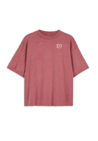 T-shirt oversize a maniche corte di colore rosa polveroso, realizzata in morbido cotone con una grafica discreta sul petto e una vestibilità rilassata.
