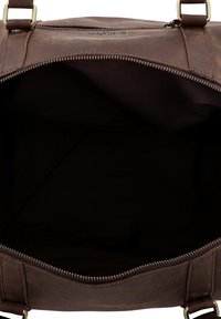 Bolso de cuero marrón con cierre de cremallera, interior vacío y dos correas para los hombros. La textura es suave con detalles mínimos.