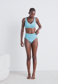 Set de sutien de culoare albastră deschisă și chiloți cu talie înaltă, fabrică netedă și design minimalist, fără modele sau embellishments vizibile.