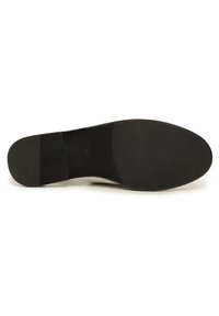 Semelle de chaussure noire avec une surface texturée, une forme arrondie et une légère élévation du talon. Dotée d'une finition lisse et d'un détail de logo discret.