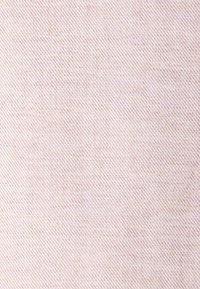 Tessuto intrecciato di un delicato rosa chiaro con un sottile motivo diagonale e una finitura fine, adatto per varie applicazioni tessili.
