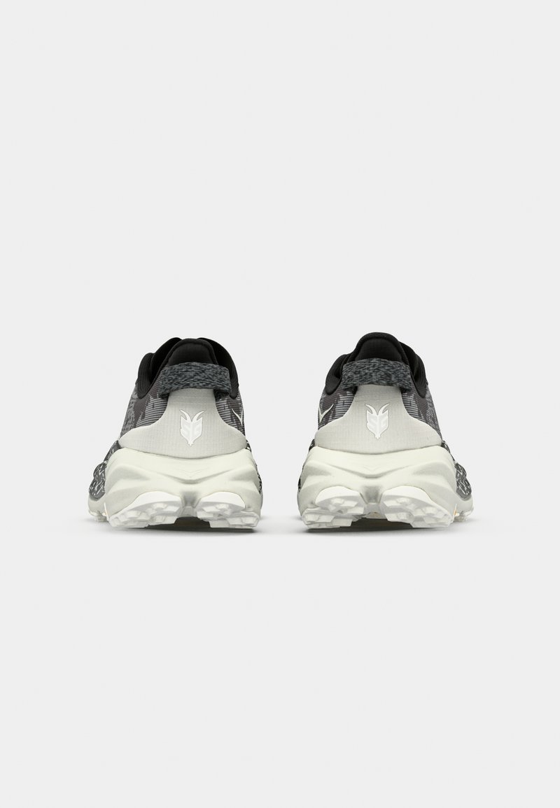 Czarno-szare buty sportowe z teksturowaną cholewką, wyściełanym kołnierzem i grubą białą podeszwą. Wyróżniające się logo na pięcie i szczegółowy bieżnik.
