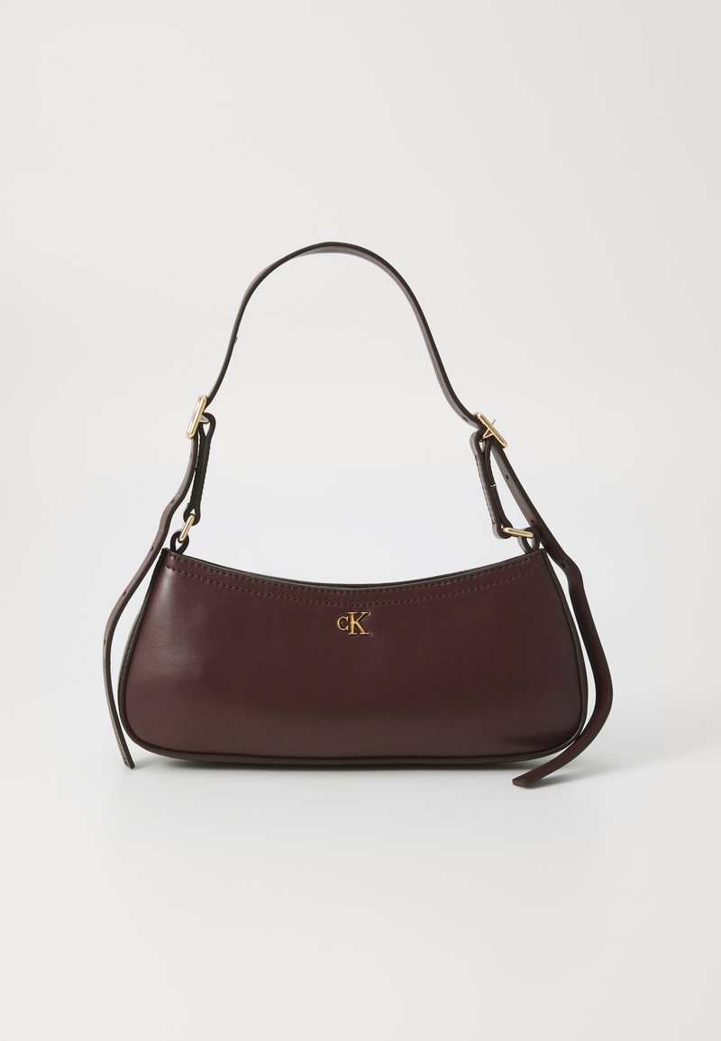 Bolso de mano de cuero burdeos con una silueta curvada, que presenta un logo dorado y una sola correa ajustable. Textura suave, costura mínima.