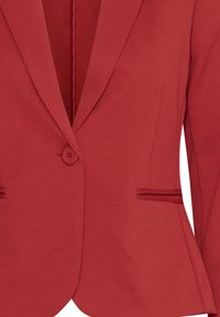 Blazer rouge cintré avec une fermeture à un bouton, des revers crantés et deux poches horizontales fenduées à la taille.