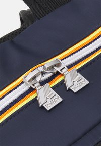 Zaino blu navy con doppia cerniera e finiture in argento, impreziosito da strisce gialle, arancioni e blu navy su un nastro bianco.