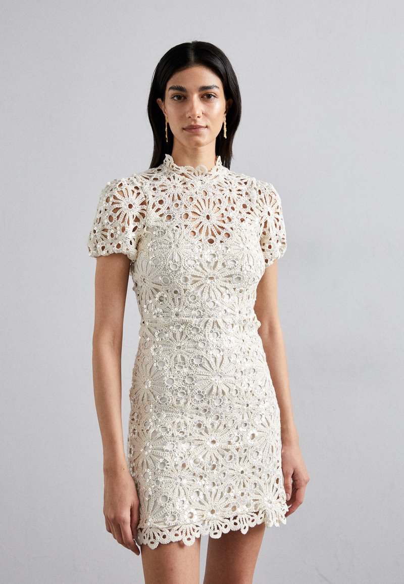 Spitzenkleid in Elfenbein mit floralem Häkelmuster, kurzen Puffärmeln und einem gewellten Saum, das filigrane Details aufweist.