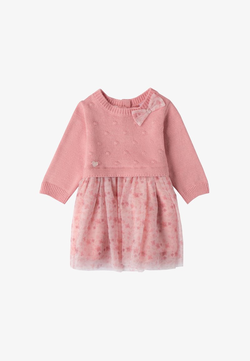 Roze gebreide jurk met lange mouwen, textuurrijke buste en rokgedeelte van tule met bloemenpatroon. Voorzien van een strikaccent op de schouder en een hartdetail.