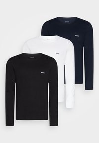 Trois t-shirts à manches longues en noir, blanc et marine. Matériau en coton avec logo sur la poitrine, encolures arrondies et coupe droite.