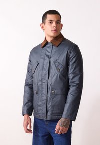 Gray waterproof jacket with a brown corduroy collar, two large front pockets, and snap button closures. Smooth texture and fitted design.