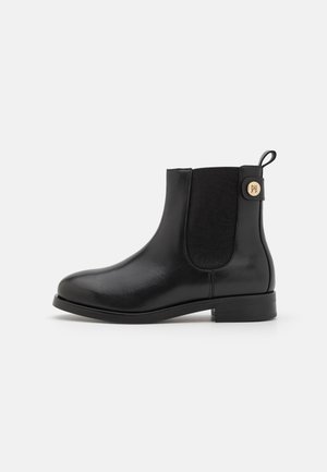Mustad musta nahast ankle boot, millel on sile nahk, elastsed külgpanelid ja kontrastne kangas seljaosa. Omab ringikujulist logo aktsenti.