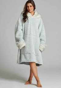 Jasnoniebieska, oversize'owa bluza z kapturem z puszystym białym kołnierzem i mankietami; posiada dużą kieszeń z przodu oraz miękką, fakturowaną powierzchnię.