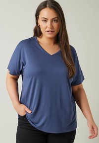 Marinblå V-ringad T-shirt med korta ärmar, tillverkad av mjukt tyg, med en avslappnad passform och sidslitsar för ökad komfort.