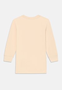 Jasno beżowa longsleeve koszulka typu crewneck pokazana z tyłu na białym tle.