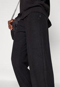 Champion ELASTIC CUFF PANTS QUICK DRY - Treniņtērpa apakšdaļas - black