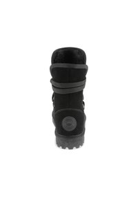 Bota negra de ante hasta el tobillo con suela de goma texturizada, punta redondeada y detalle de cordones trenzados en el eje, con un acento de logo circular.