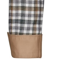 Camicia di cotone con un motivo a quadri in bianco, marrone e nero, con polsini beige e una texture liscia.