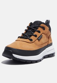 Chaussure de randonnée en cuir marron avec accents noirs, semelle intermédiaire blanche, surface texturée et lacets noirs. Dotée d'une semelle en caoutchouc durable.