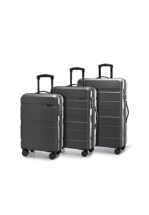 Tres maletas rígidas grises de diferentes alturas con rayas texturizadas, asas extensibles y cuatro ruedas que giran suavemente cada una.