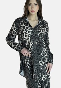 Blouse imprimé léopard en noir, gris et crème, avec un design à boutons, des manches longues et une coupe fluide et ample avec un ourlet arrondi.