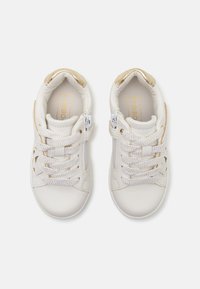 Witte kindersneakers van een glad synthetisch materiaal, met gestructureerde veters, gouden accenten op de hiel en zijritsen.