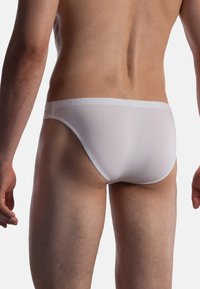 Weiße Herrenunterhosen verfügen über einen weichen Gummibund und eine glatte Textur, entworfen mit einem minimalistischen Schnitt und ohne sichtbare Muster.