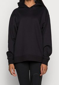 Czarna bluza z kapturem o luźnym kroju, wykonana z miękkiego materiału. Posiada ściągacze na mankietach i u dołu oraz subtelne logo z przodu.