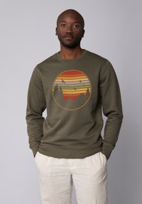 Olijfgroen sweatshirt met een ronde grafische afbeelding van zonsondergangstrepen en gesilhouetteerde bomen. Lange mouwen en ribgebreide manchetten.